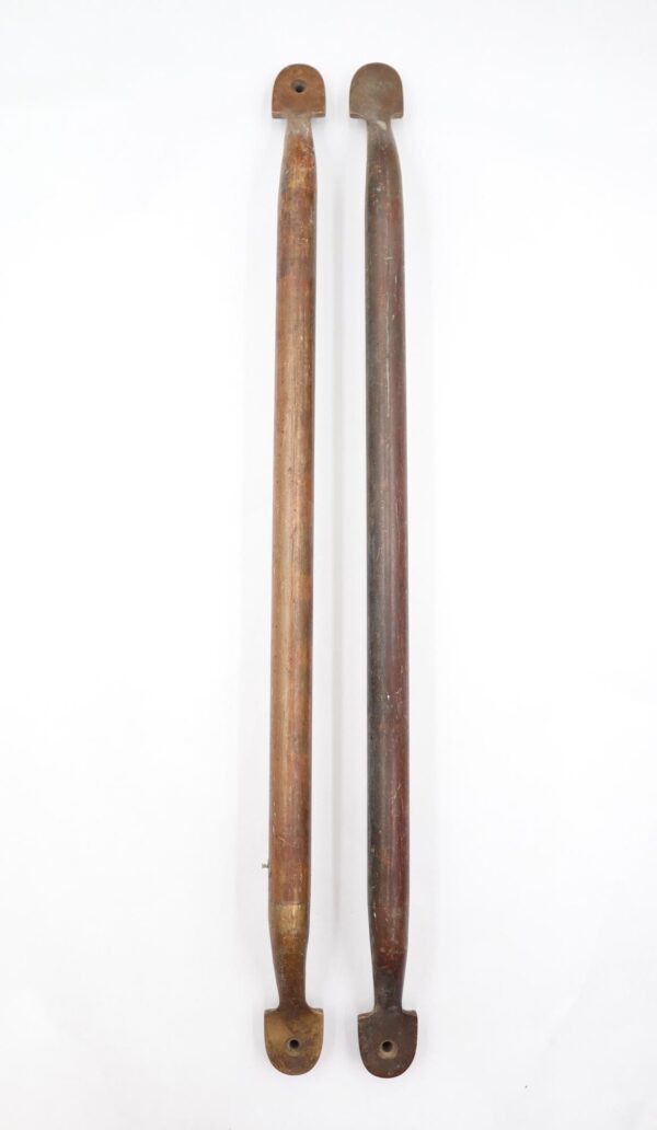 Pair of reclaimed brass door push bars with rounded flat ends, shown side by side and featuring surface wear and varied antique finishes.