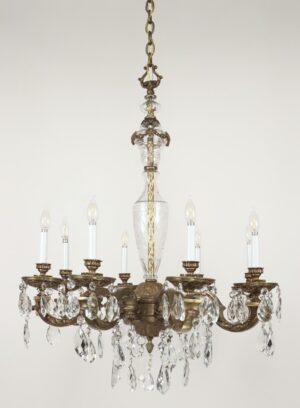 Victorian-style chandelier with eight scroll arms, an etched glass center stem, and hanging crystal prisms.