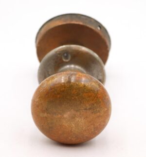 Vintage bronze door knob set with a flush mount handle, shown from the front with visible surface wear and a patinaed finish.