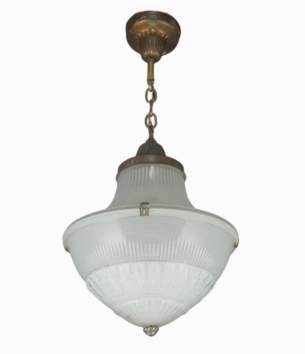 Industrial pendant light with an acorn-shaped frosted prismatic glass globe, antique brass chain fitter, and a hanging ceiling canopy visible above.