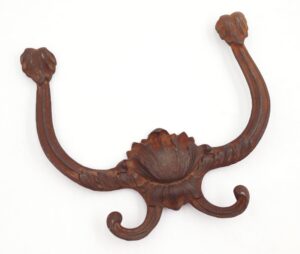 Victorian cast iron hall tree hook with four curved prongs and a floral center detail.