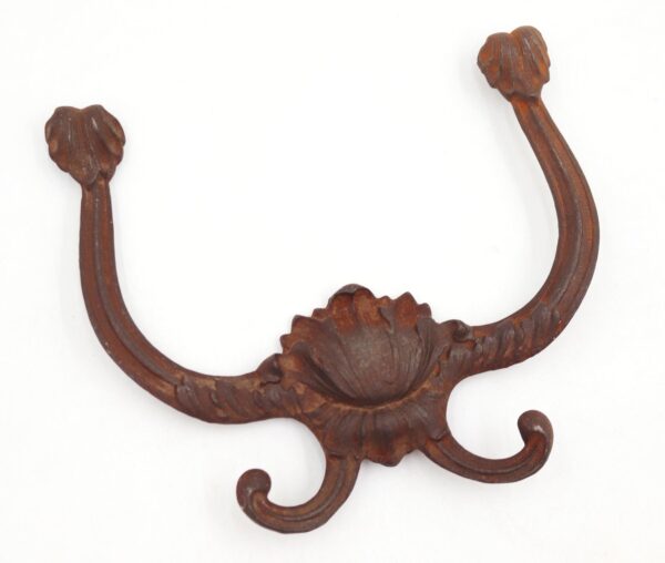 Victorian cast iron hall tree hook with four curved prongs and a floral center detail.