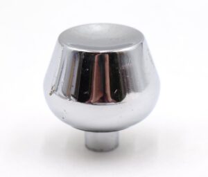 Close-up of a chrome-finished brass cabinet knob with a concave tulip shape and visible surface wear.