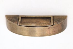 Reclaimed brass semi-circle drawer pull with a central label slot and worn antique finish, shown front view.