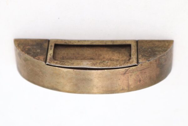 Reclaimed brass semi-circle drawer pull with a central label slot and worn antique finish, shown front view.