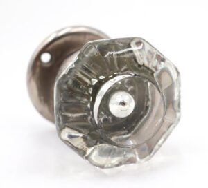 Clear octagon glass door knob with a brass rosette, shown in close-up with the dummy spindle visible behind it.