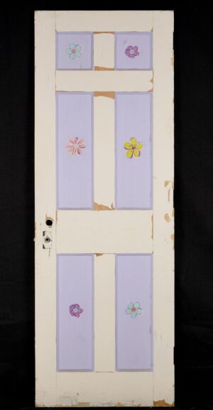 Vintage six-panel privacy door painted white and purple, shown with surface wear, chipped paint, a privacy latch hole, and original brass hardware attached.