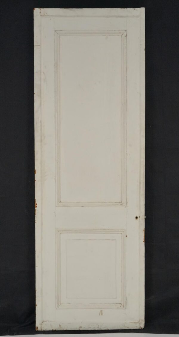 Vintage white wood passage door with two panels, shown front-on with surface wear along the edges and finish.
