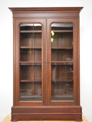Front view of walnut bookcase with glass doors and shelves, highlighting wood grain and clear shelving.