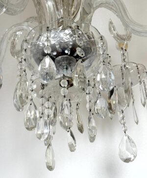 Clear crystal chandelier with five arms and hanging drops, shown in close-up from below.