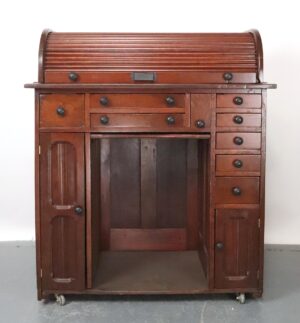 Front view showing drawers, cabinets, and center open space on small wheels against a plain backdrop. Close-up of side panel highlighting grain texture and drawer handles with cabinet door details. Angled view displaying both the desk’s curved roll-top and multiple storage compartments. Detail shot of the lower drawers slightly open to reveal interior structure and wheel base. Top-down perspective emphasizing the roll-top cover’s pattern and finish against a neutral background.