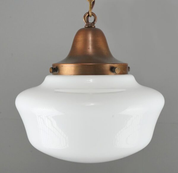 Schoolhouse pendant light with a white milk glass globe and antique brass chain fitter.