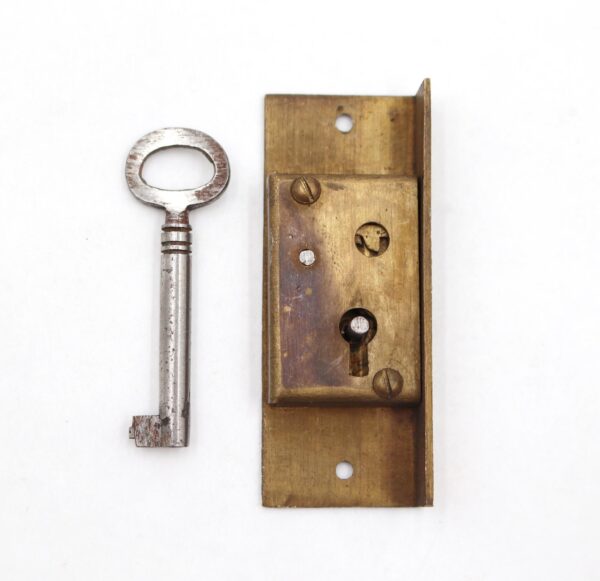 Left-hand half mortise cabinet lock in antique brass with a steel key, shown with the lock body and key side by side.