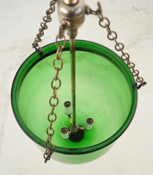 Top view of a green bell jar pendant light with antique brass hardware and three bulb sockets visible inside.