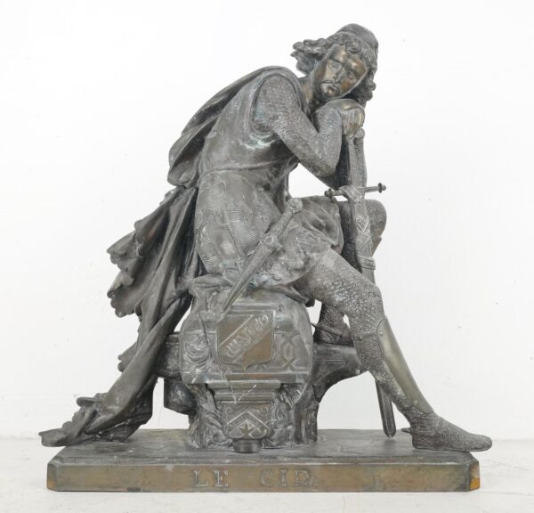 Seated medieval knight in chainmail, head resting on hand, sword in other hand, LE CID on base, by Eugene Laurent, front view.