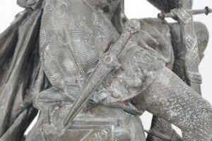 French bronze sculpture of Le Cid, knight in chainmail with engraved attire and dagger at waist, detailed front torso view.