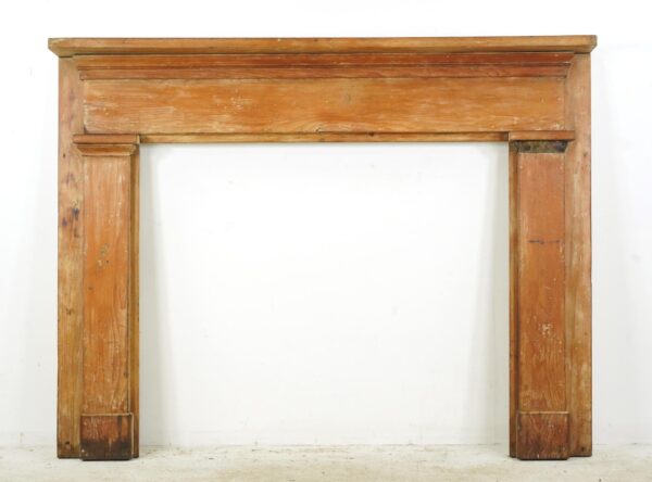 Traditional wood fireplace mantel with a simple design and light wood tone, shown front view with visible surface wear and a missing molding piece on the right top column.