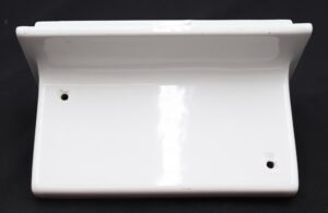 Rectangular white ceramic bathroom shelf with two predrilled drainage holes and visible surface wear and chips.