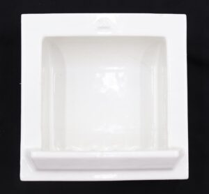 Square porcelain soap dish with a recessed center and raised front ledge, shown in white with visible surface wear and small chips on the mounting edges.