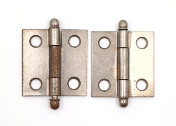 Pair of vintage steel cabinet door hinges shown side by side, each with four countersunk screw holes and visible surface wear; one hinge shows heavier rust, and both are right hand hinges.