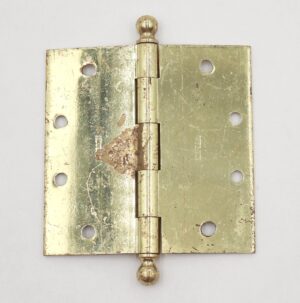 Polished brass door hinge with ball tips, five knuckles, and a template hole pattern, shown closed and viewed from the front.