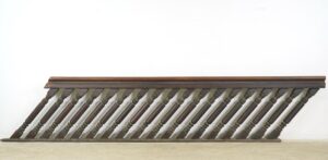 Antique stair railing set with a dark wood tone, shown in a wide horizontal view with a hand-carved banister and evenly spaced turned spindles.