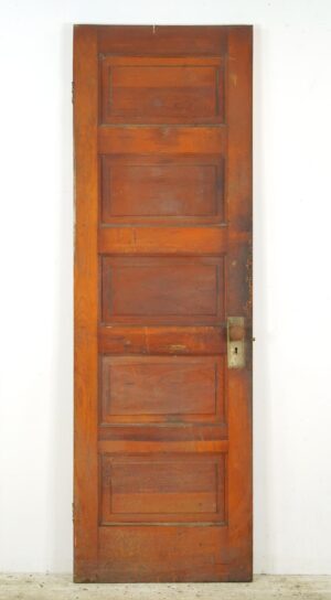 Vintage five-panel wood passage door with a dark wood tone finish, shown upright with worn surface details and an attached brass knob set on the right side.