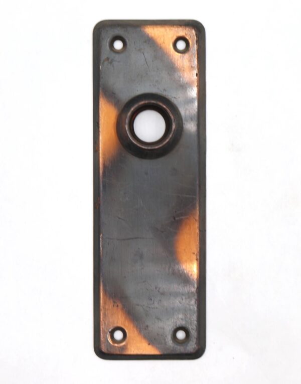 Vintage steel door back plate with a japanned black and copper finish, showing a central round opening and four screw holes.