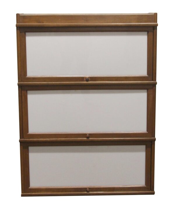 Three-section barrister bookcase with dark wood tone frames and white glass doors, shown without the base section.