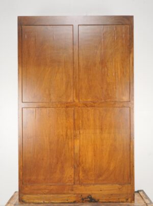 Wooden bookcase with two plain paneled doors, shown front on, in a medium wood tone with visible surface wear and minor scuffs.