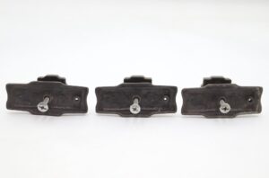 Three vintage drawer cabinet knobs with an antique brass finish and mounting screws, shown from the back side in a set of three.