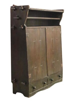 Dark wood tone Arts and Crafts storage cabinet with paneled doors, open upper shelf, and two bottom drawers shown at a slight angle.