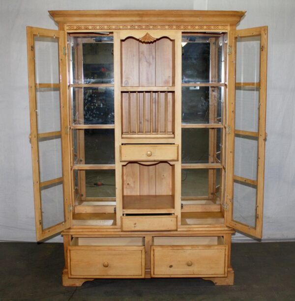 Traditional pine storage and display cabinet with open glass doors, interior shelves, and lower drawers shown from the front.