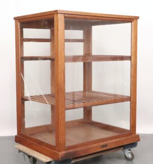 Glass-front display cabinet with a medium wood tone frame, two slatted shelves, and an open interior.
