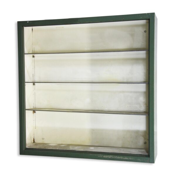 Industrial steel cabinet with a green frame and four shelves, shown front on with surface wear and an open, doorless interior.