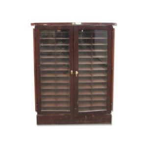 Commercial wood cabinet with two chicken wire glass doors, brass hardware, and slatted shelves visible behind the doors.