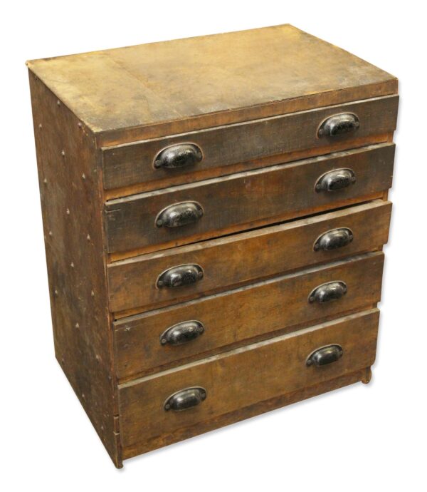 Vintage industrial workshop chest of drawers with five drawers and steel bin pulls, shown in dark wood tone with heavy surface wear and staining.