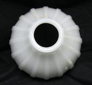 Top view of a white fluted milk glass pendant light shade with a circular opening at the center.