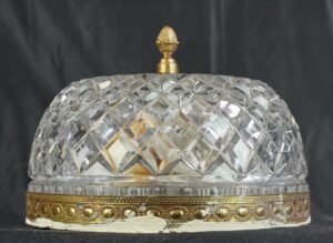Crystal flush mount light with a faceted clear dome, ornate brass rim, and pineapple finial.