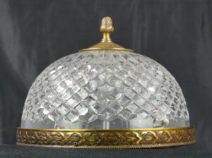 Crystal flush mount light with a faceted clear dome, ornate brass rim, and pineapple finial.