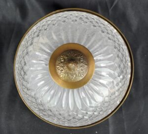 Crystal flush mount light with a clear faceted glass dome, ornate brass center detail, and polished brass rim.