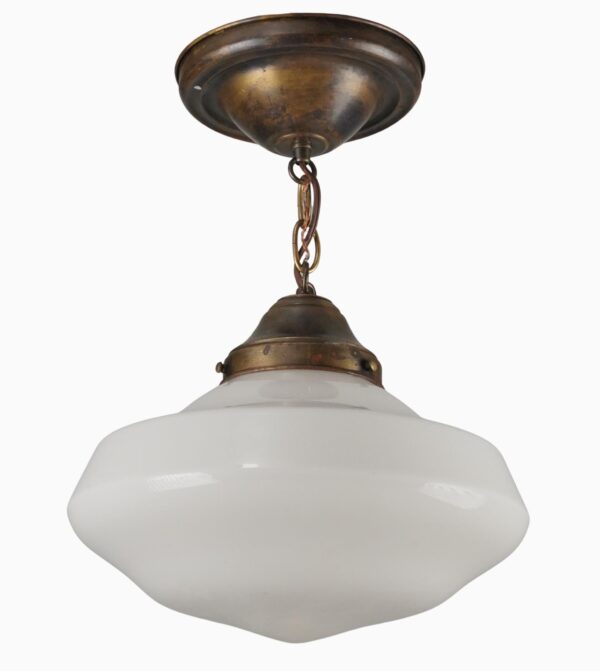 Schoolhouse pendant light with a white milk glass globe and antique brass chain fitter.
