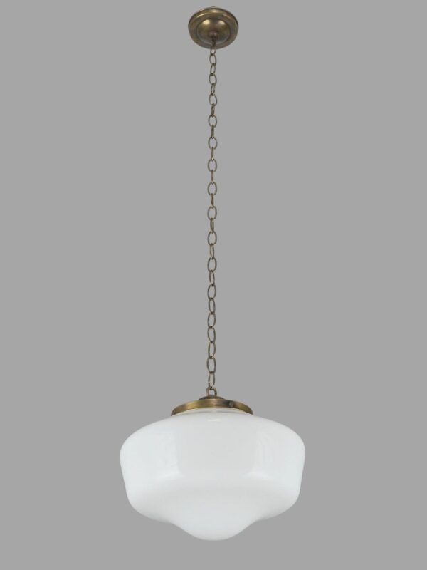 Schoolhouse pendant light with a white milk glass globe and antique brass chain fitter.
