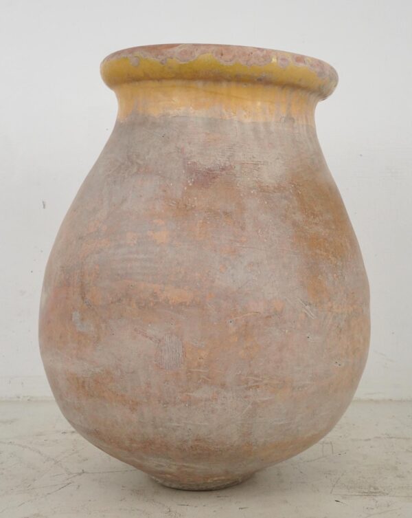 Large terra cotta olive jar with a rounded body and wide flared rim, shown front view with aged surface wear and pale ochre glaze visible on the upper edge.