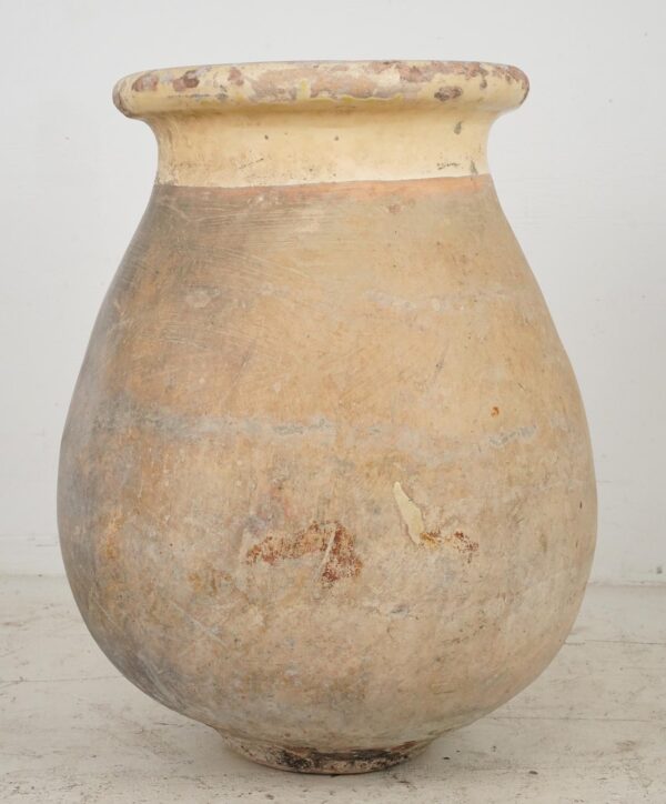 Tall Biot olive jar in gray and tan terra cotta with a wide flared rim and visible age-related wear and chips.