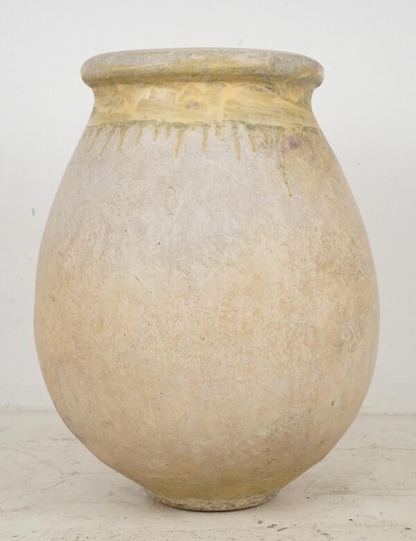 Large olive jar with a rounded body, narrow foot, and thick flared rim, shown in tan-gray terra cotta with a worn natural glaze and age marks.