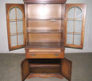 Traditional walnut storage hutch with arched glass doors, open upper shelves, a center drawer, and a lower cabinet with solid doors.