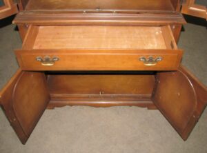 Traditional walnut hutch with open cabinet doors, a center drawer, and visible surface wear on the wood.
