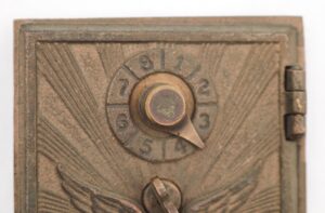 Vintage bronze combination box door with a numbered dial and a flying eagle relief.