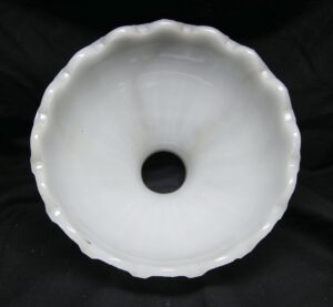 Top view of a white milk glass pendant light shade with a fluted edge and central fitter opening.